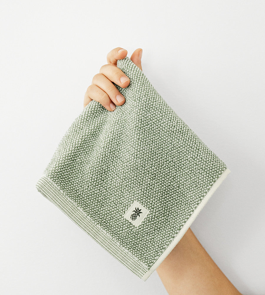 models hand holding up a washcloth~Oasis Green