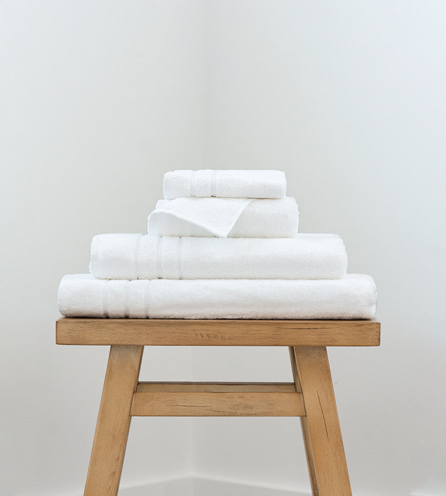 a bath sheet, bath towel, hand towel and washcloth on a stool