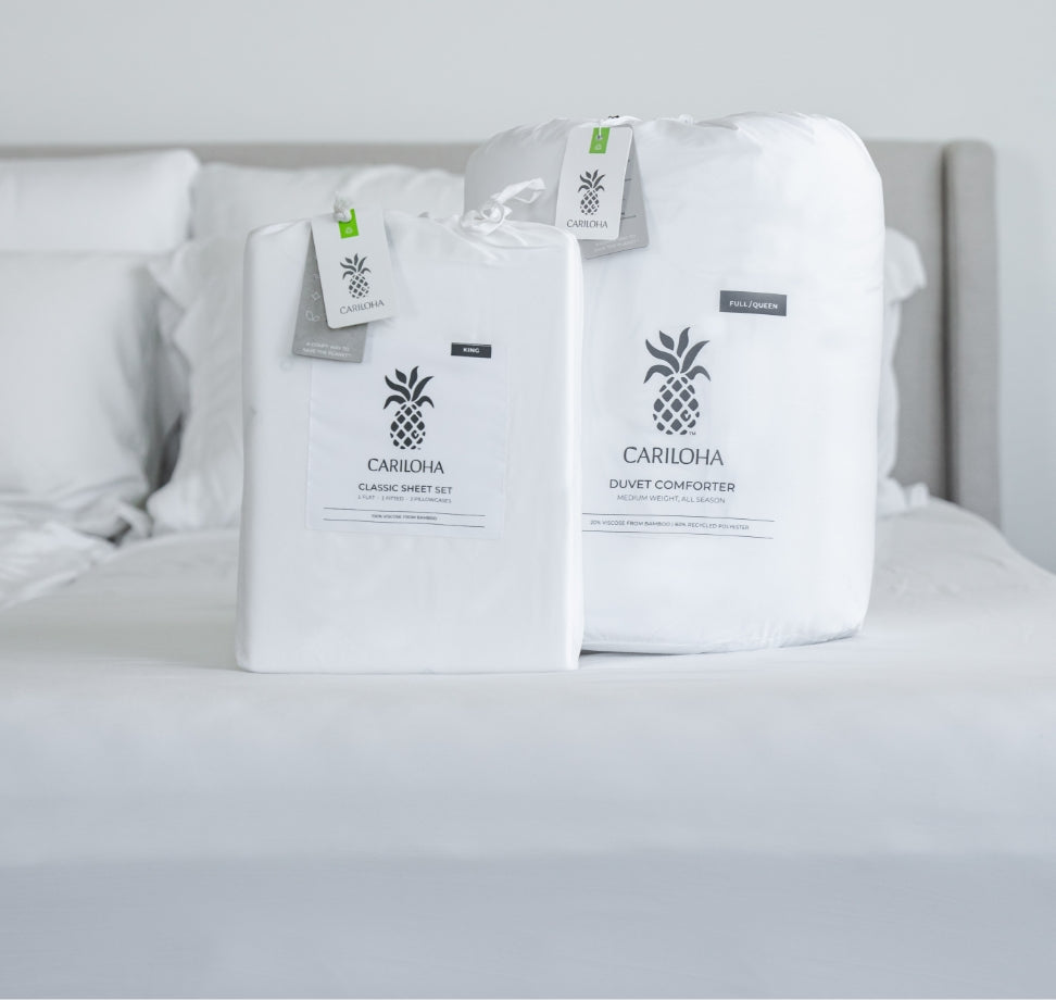 Cariloha Retreat Sheet Set and Duvet Comforter wrapped in branded packaging, staged on a bed