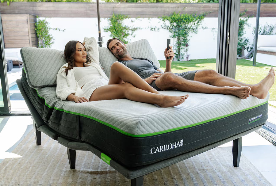 a man and woman lying on a cariloha retreat mattress and comfort base