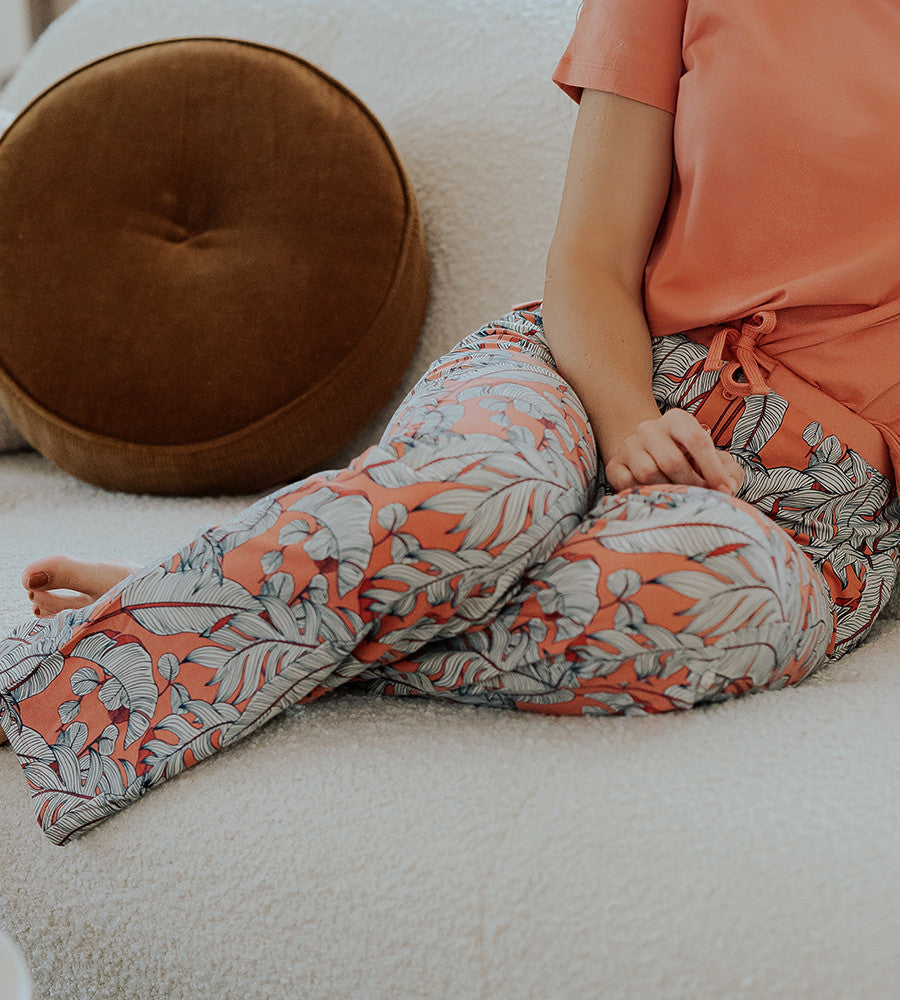 view of models legs wearing blush foliage print pants