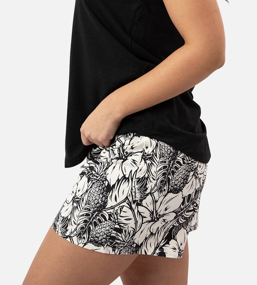 side view of models legs wearing soft black pineapple print sleep shorts