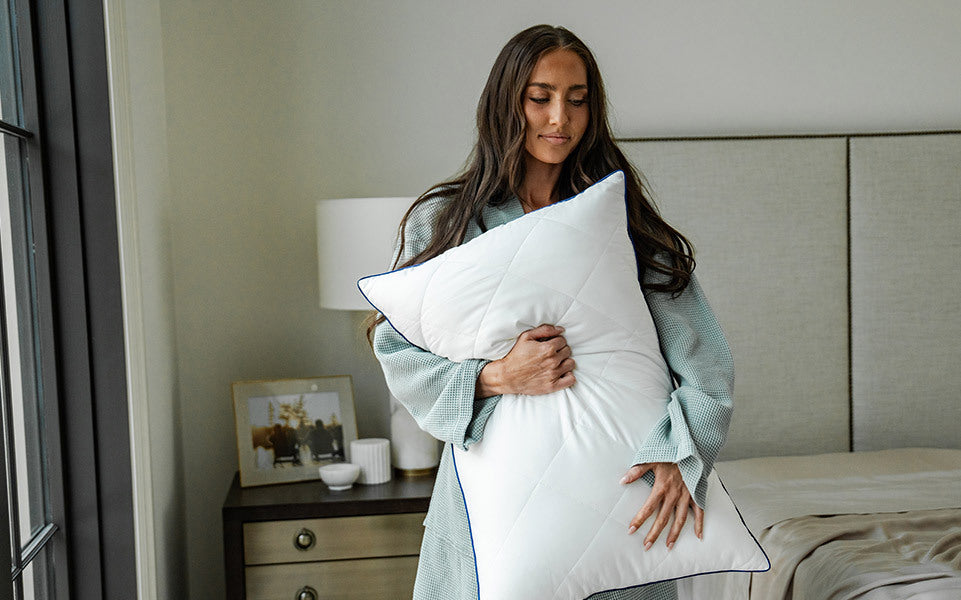 a woman hugs a cariloha down pillow