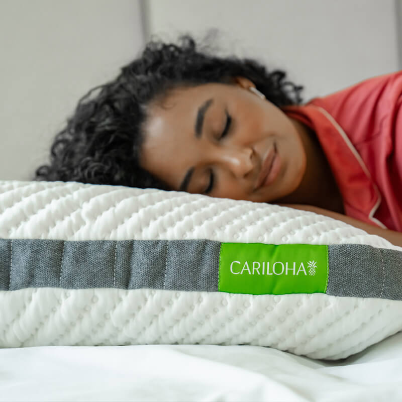 a woman sleeping on a cariloha pillow